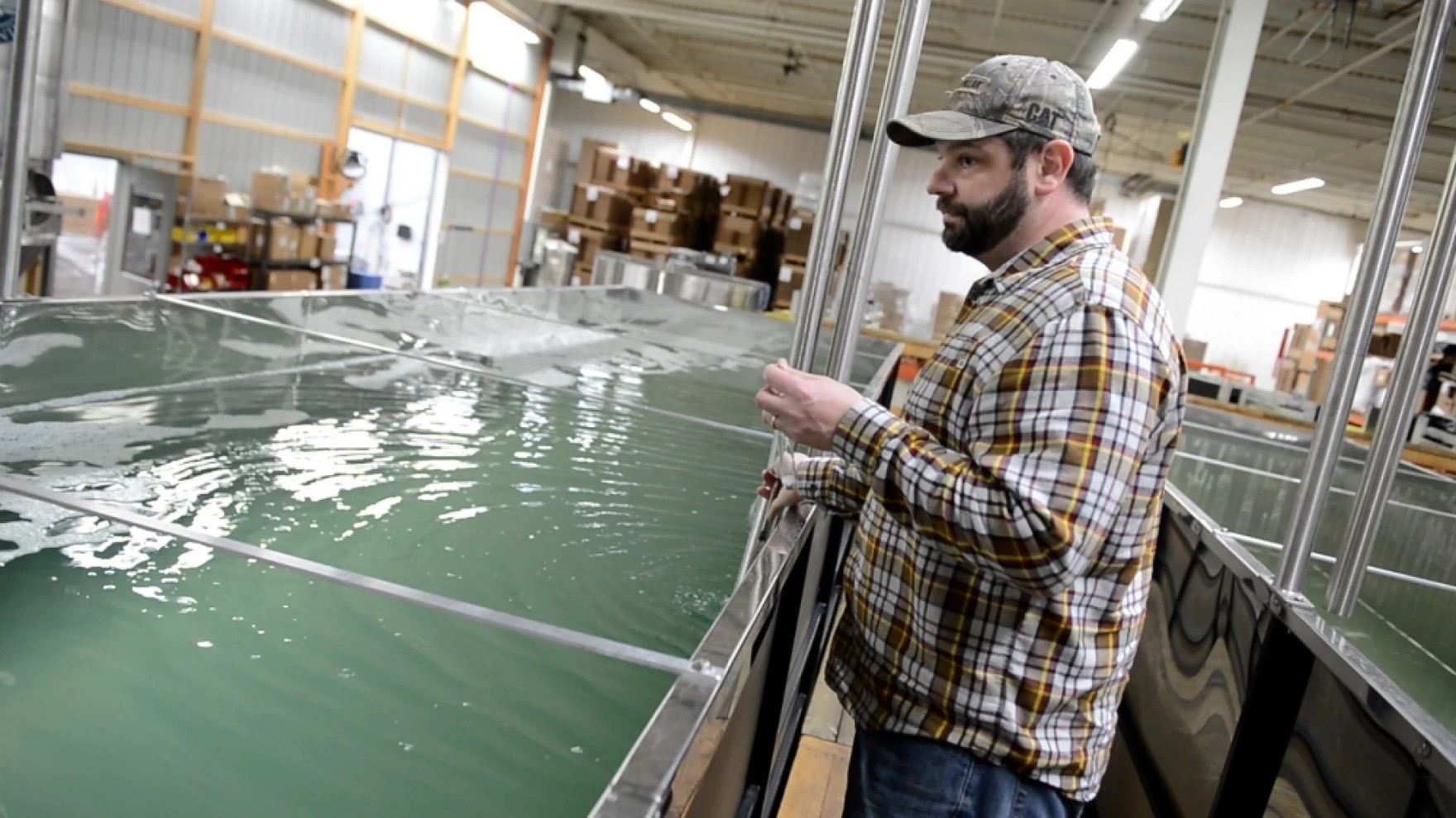 Nate Bissell watches as sap is pumped into holding tanks at the farm's production facility in Jefferson, OH. [Jean-Marie Papoi/ideastream]